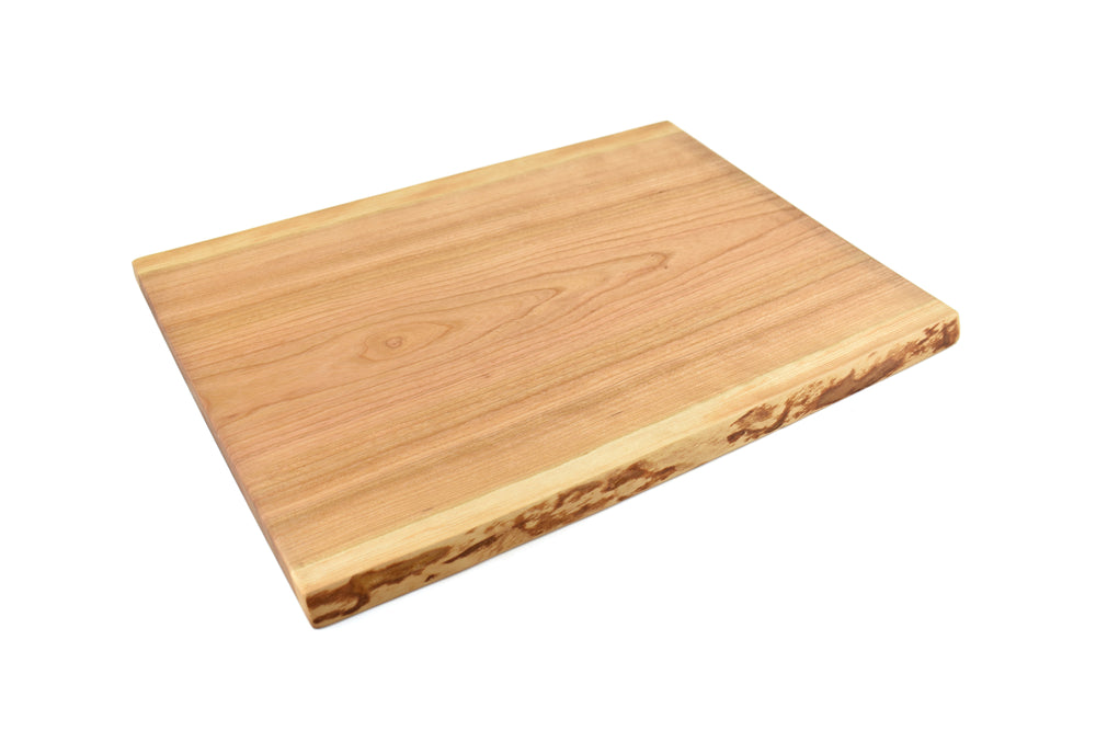 Artisan live edge cherry serving board with natural bark edge