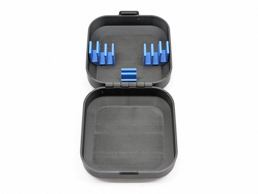 Top-down view of the open case, blue battery clips in one half and the printed hinge across the middle