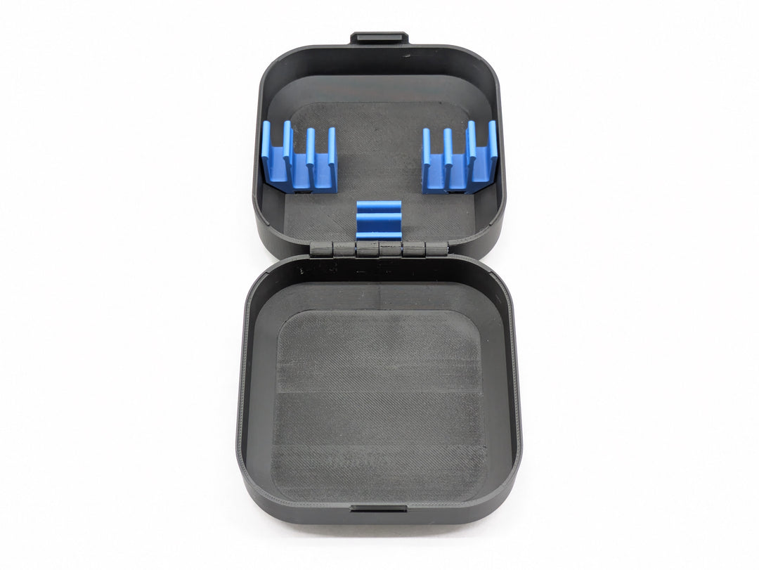 Top-down view of the open case, blue battery clips in one half and the printed hinge across the middle