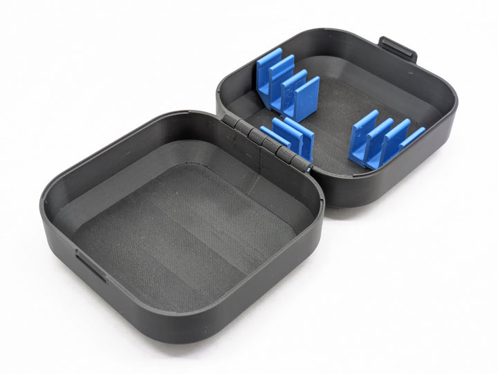 The open case at an angle, showing the blue battery clips and the empty second half