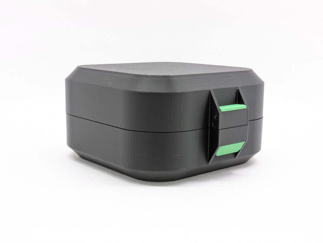 Closed black case from the front, showing the green latch
