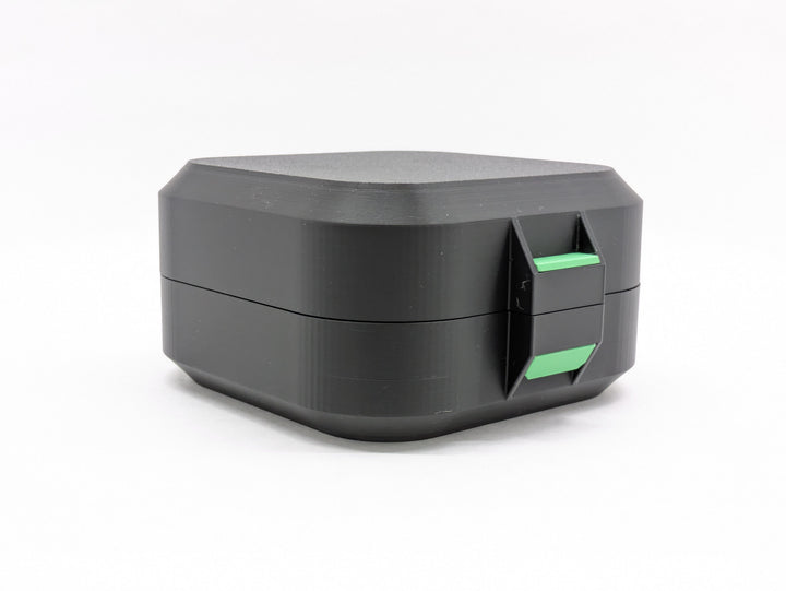 Closed black case from the front, showing the green latch