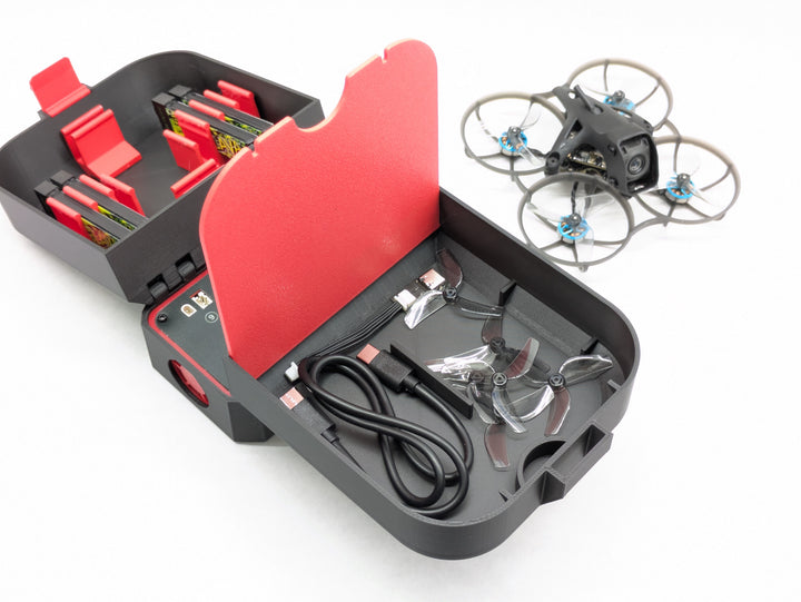 Printed drone case interior showing the USB-C cable and spare prop storage under the charger